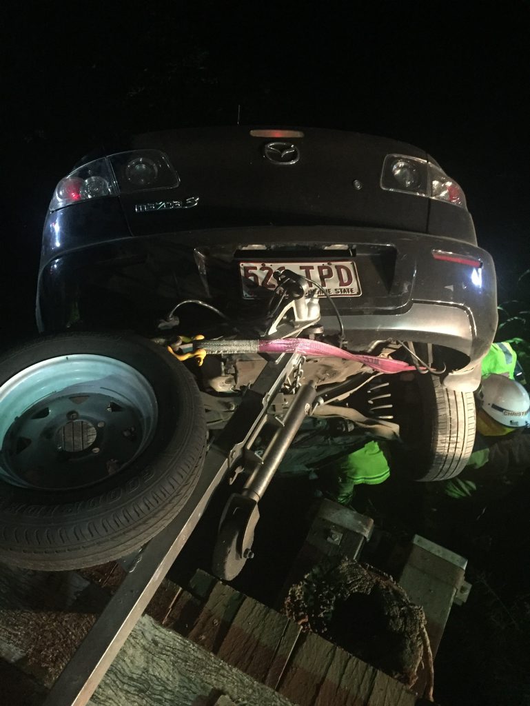 The car dangles off Running Creek Bridge with the injured driver trapped inside. The car dangles off Running Creek Bridge with the injured driver trapped inside.